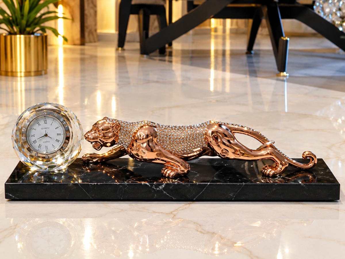 luxurious crystal clock and a rhinestone-encrusted rose gold panther figurine set on a polished black marble base.